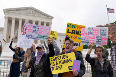people protest outside supreme court with pro-abortion signs