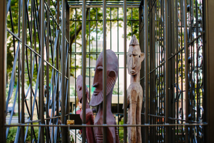 african sculptures inside fence in sculpture "mind forged manacles/manacle forged minds"