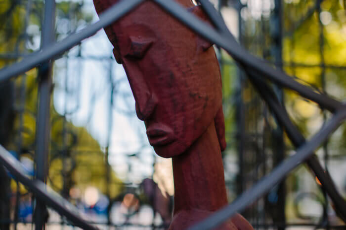 close up of sculpted human face through fence