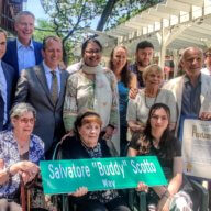 people with buddy scotto street sign