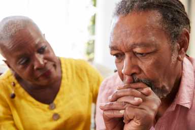 Senior Woman Comforting Man With Depression At Home