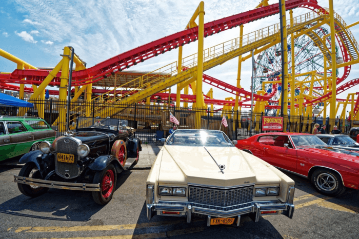 classic cars in front of rollercoasters at coney island