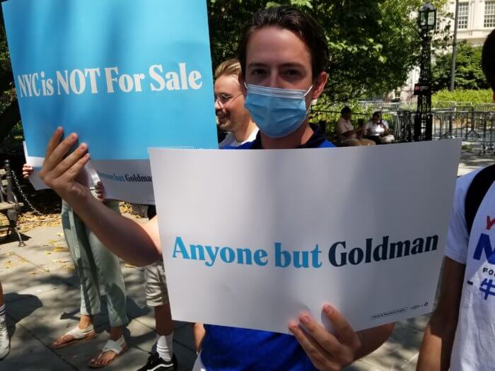 supporters hold signs against dan goldman at press conference