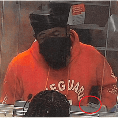 The alleged lifeguard bandit is seen in a red "Lifeguard" hoodie at the scene of the crime. Ricardo Subero, the defendant, suspectedly flashed a gun to the bank teller while demanding money.