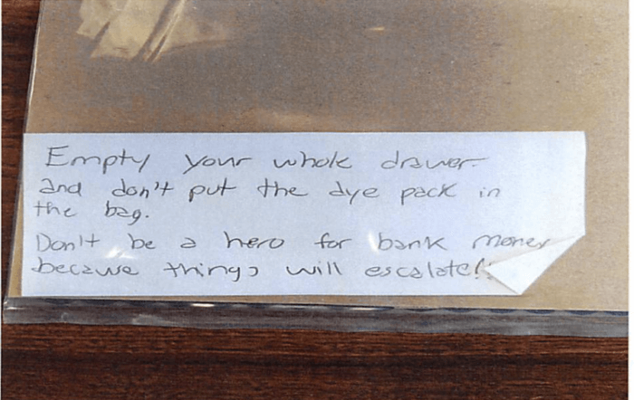 The note the bank robber handed to the bank teller demanding they empty their drawer.