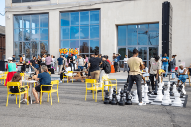 people at tables at brooklyn navy yard beats and eats