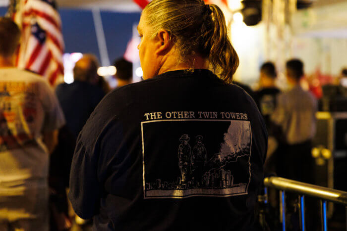 woman stands with back to camera and FDNY 9/11 shirt