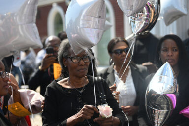 woman holds balloon at liliana merdy funeral service