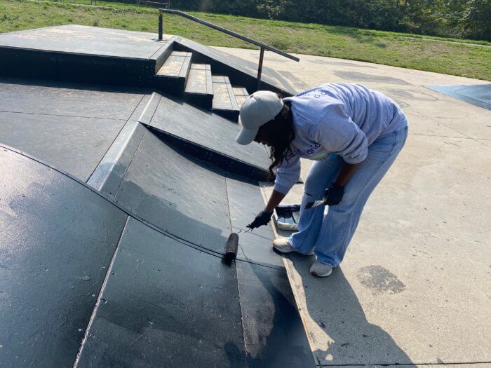 person painting skate ramp