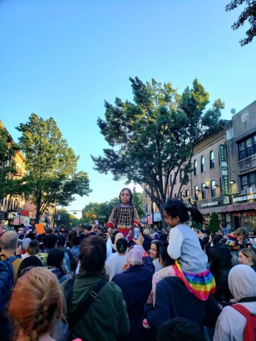 Communities gather for pictures with roughly 12 foot puppet.