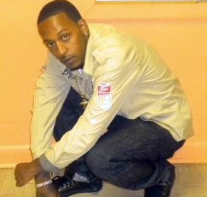 saheed vassell crouched in front of yellow wall