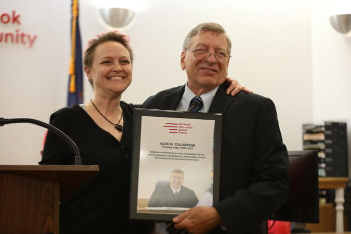 alex calabrese and pauline nevins pose with plaque