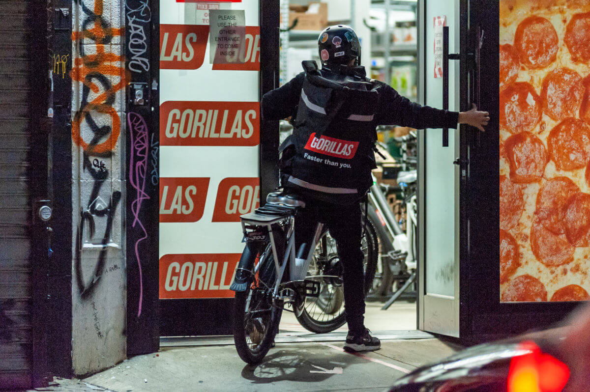 Gorillas worker going into dark store on bike