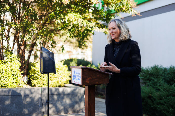 woman speaking at podium at the doe fund event