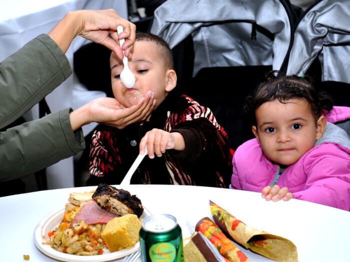 kid being fed at thanksgiving meal