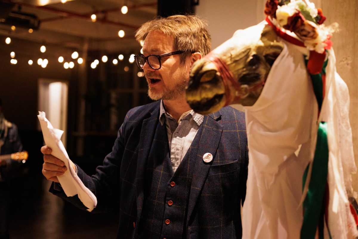 man reads with mari lwyd horse skull puppet