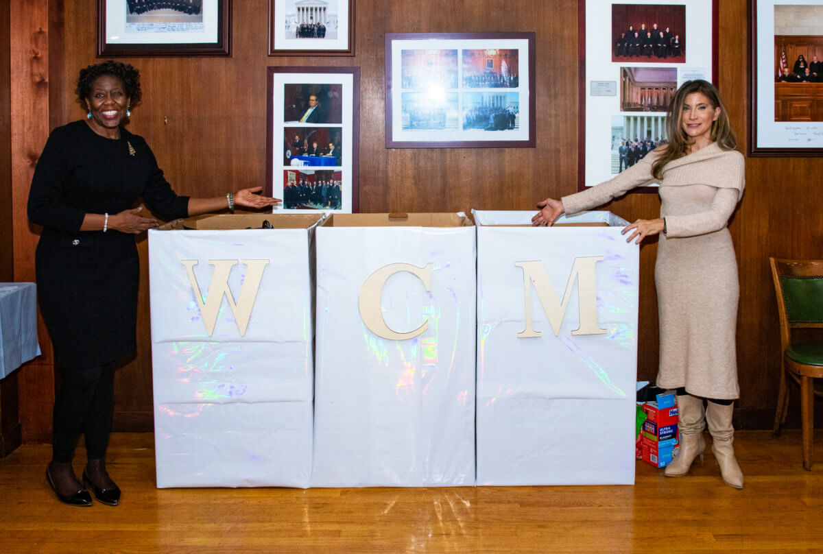 Joy Thompson and Ronit Abraham presents boxes of warm winter jackets.