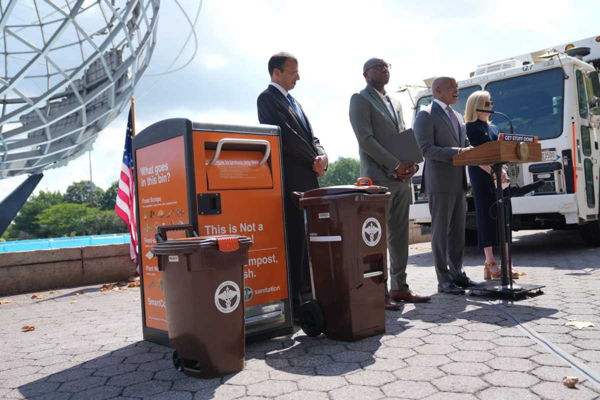eric adams standing with composting bin