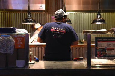 Pig Beach employees working behind the counters on a busy Wednesday night.