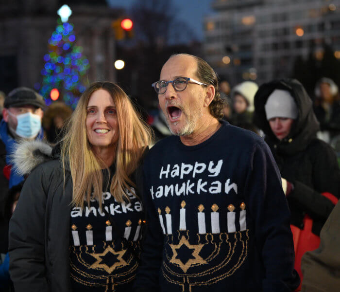 people in hannukah sweaters