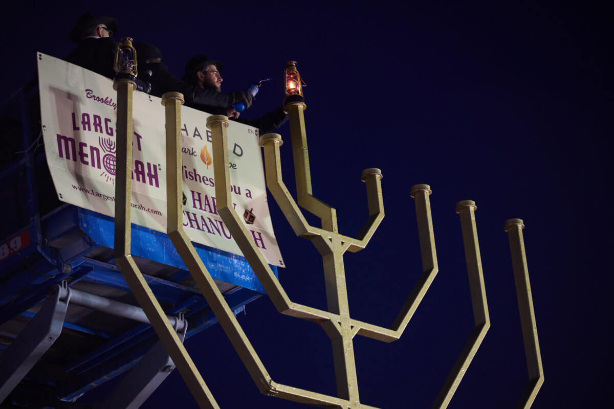 people lighting brooklyn's largest menorah