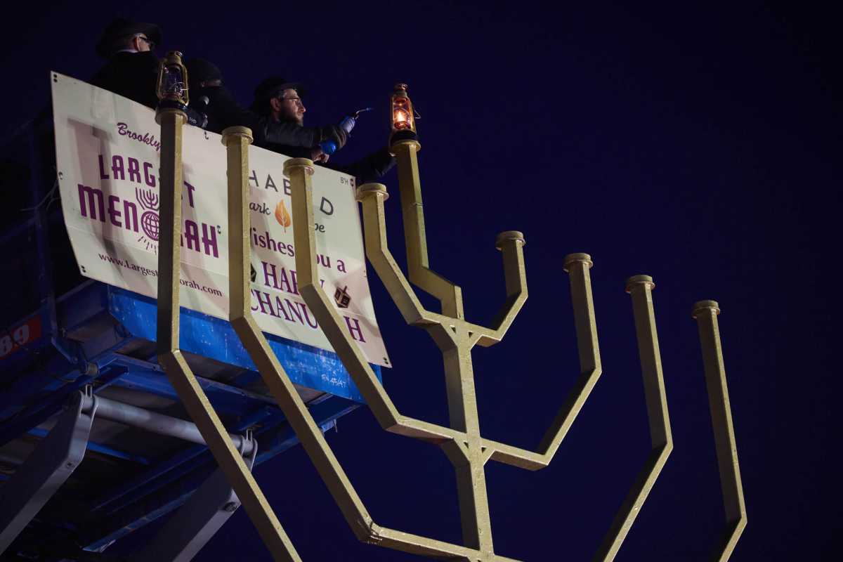 people lighting brooklyn's largest menorah