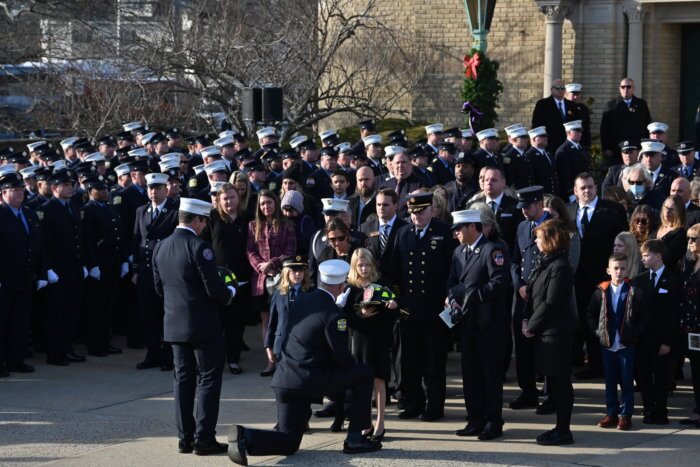 firefighter giving helmet to william moon's children