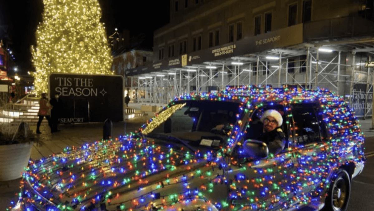 man in car decorated in holiday lights fundraising