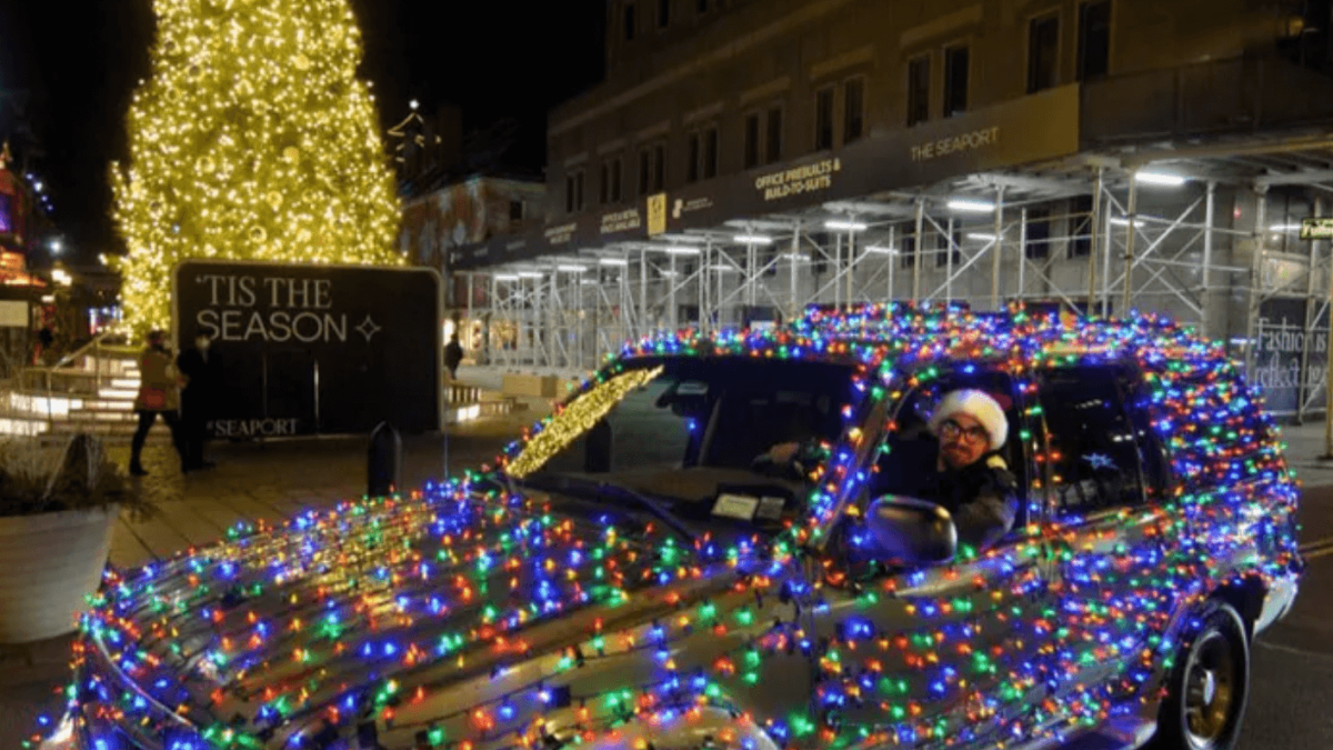 man in car decorated in holiday lights fundraising