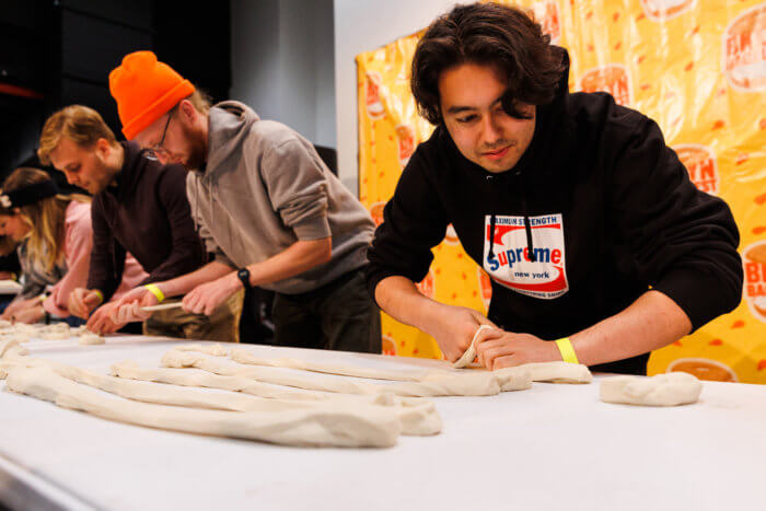 man rolling bagel dough at bagelfest