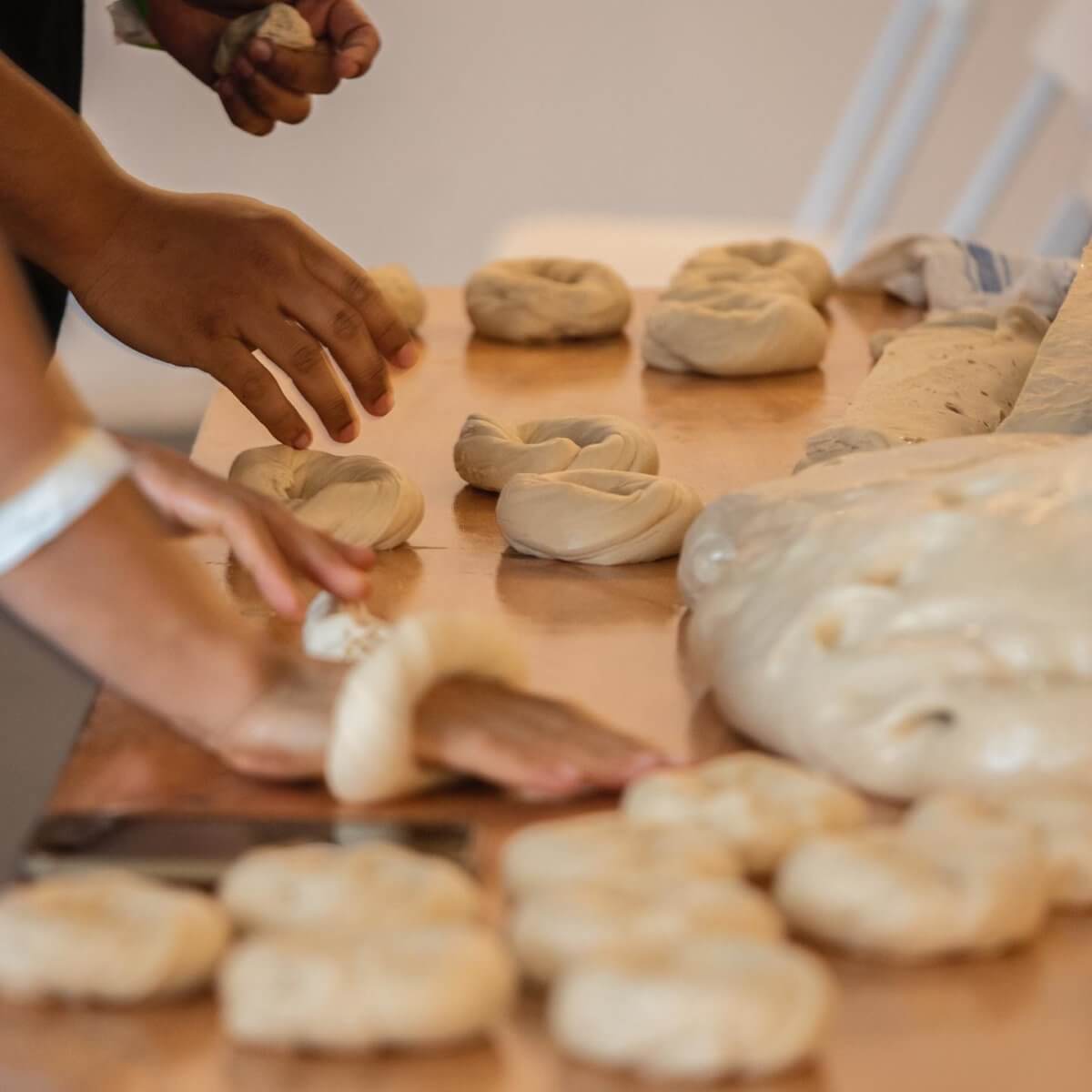people making bagels by hand
