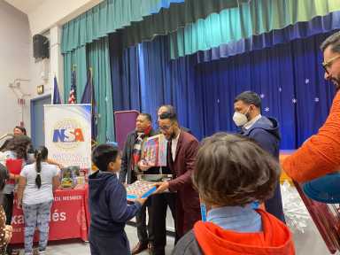 Antonio Reynoso handing out gifts at school