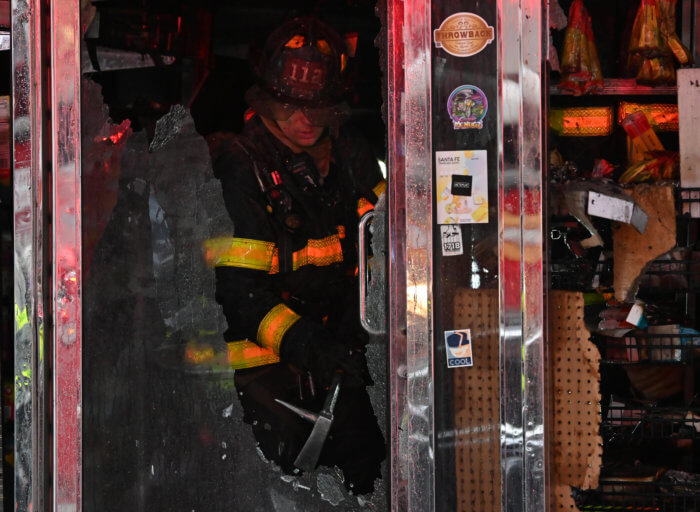 firefighter breaking glass at smoke shop fire