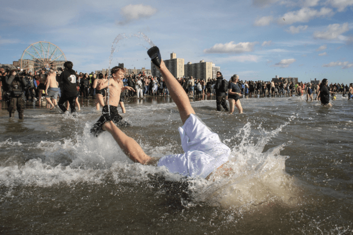 man's legs as he dives into ocean