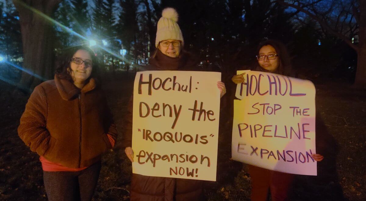 Climate advocates holding signs directed at governor hochul fracked gas pipeline