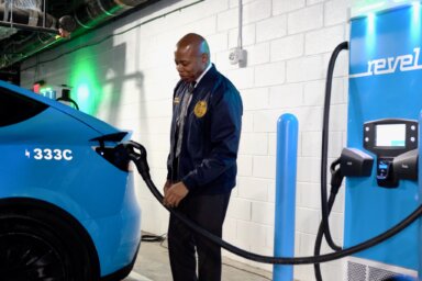 Mayor Eric Adams charges the first Revel vehicle at newly opened charging hub.