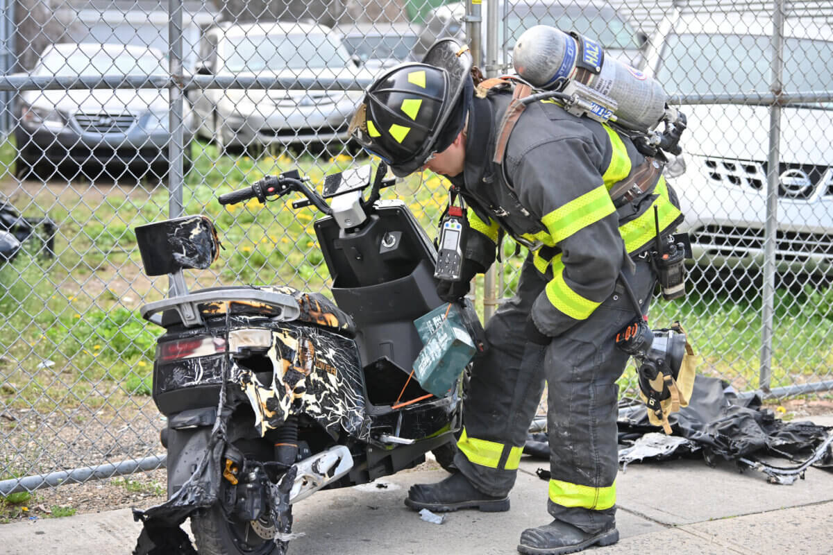 firefighter examines e-bikes after fire