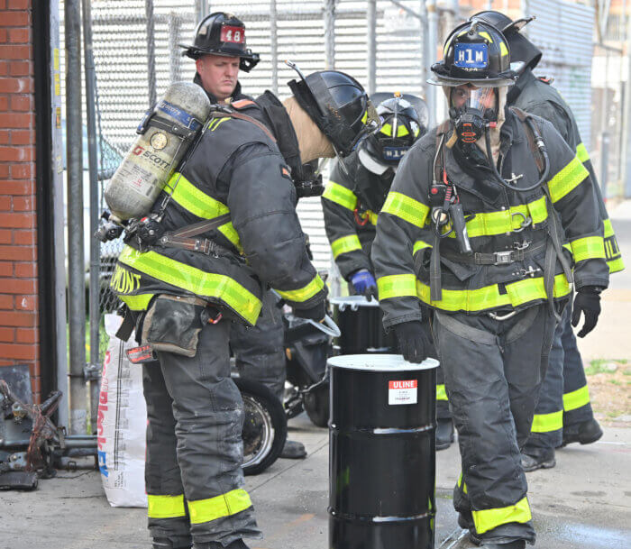 firefighters place e-bike battery in container
