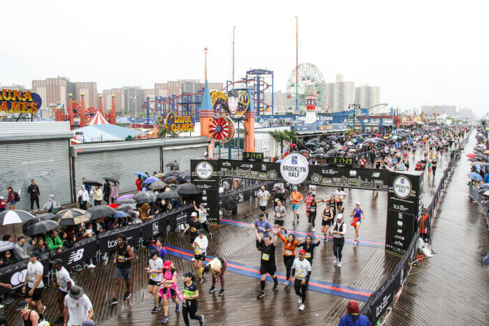 Determined and damp runners cross the Brooklyn Half Marathon finish line on Saturday, May 20.