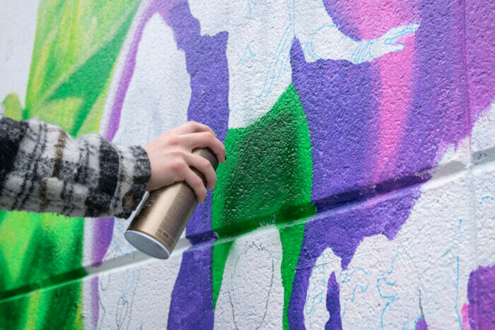 Students, Chloe Mosbacher and Matt O'Connor worked alongside Lady Pink to create the mural.