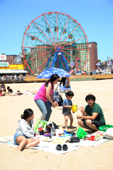 A family spent the day in the sand with waves to the left and the Wonder Wheel to the right.