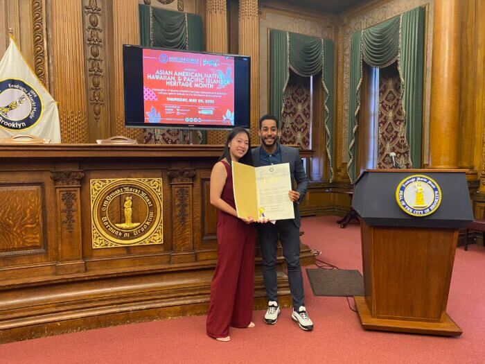 Borough President Reynoso presents a proclamation to Ashley Huang,  the Director of the School-Age Child Care Center at P.S. 153.