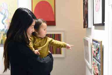 A woman and child admire artwork at an exhibition held by the Brooklyn Arts Council.