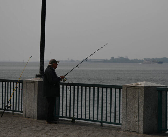 man on pier wildfire smoke