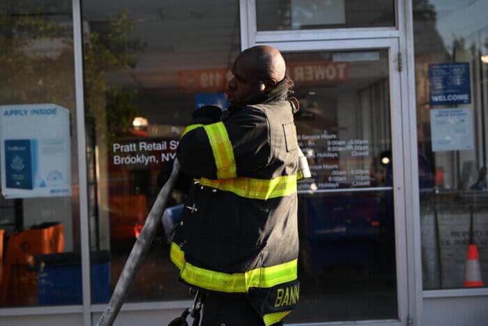 firefighter with hose at bed-stuy post office fire