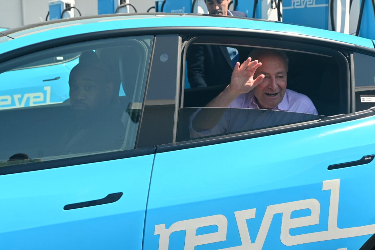chuck schumer waving from back of revel car