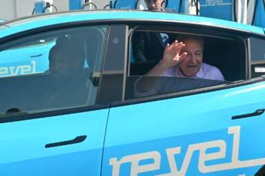 chuck schumer waving from back of revel car