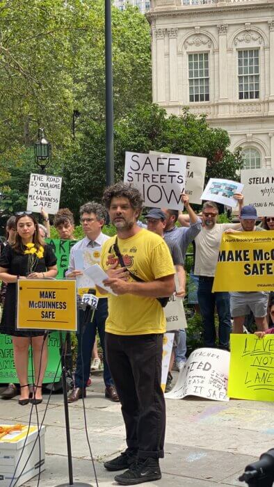 man speaking at mcguinness boulevard rally at city hall