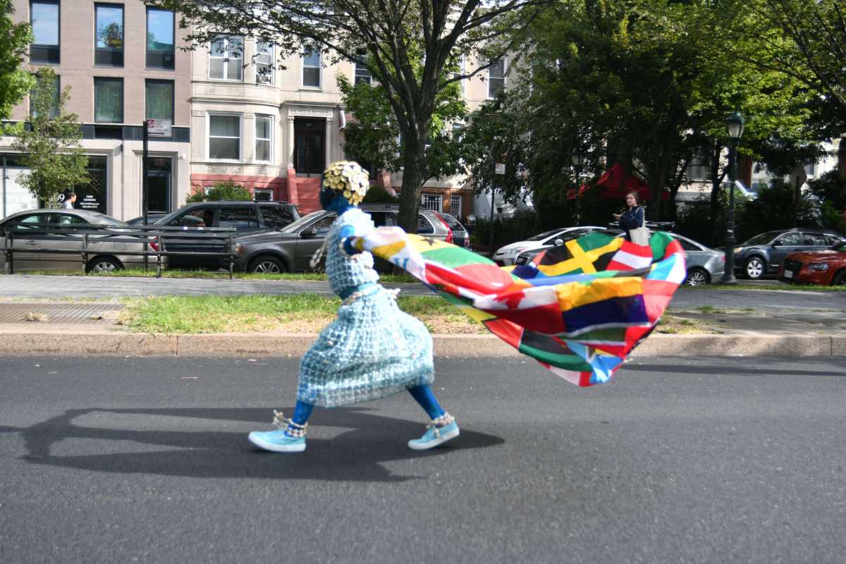 Child walks with banner of Caribbean country flags brooklyn caribbean literary festival