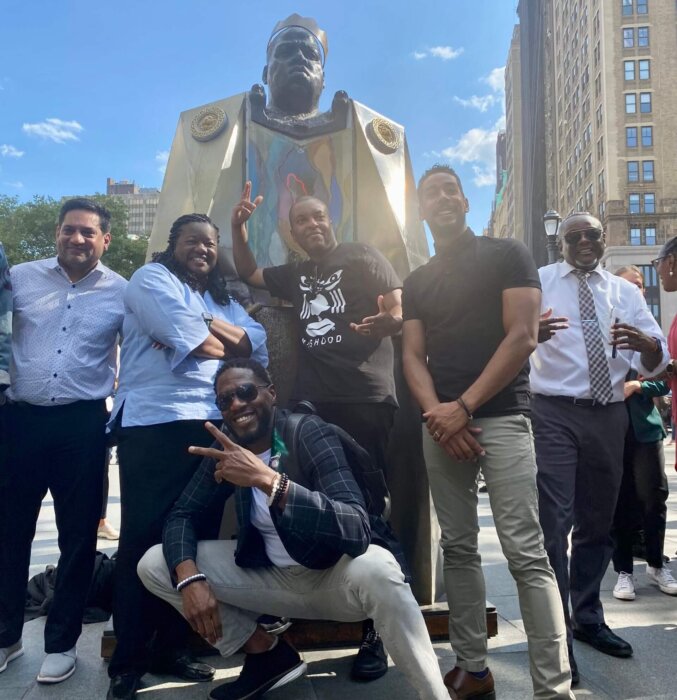 crowd posing in front of biggie statue